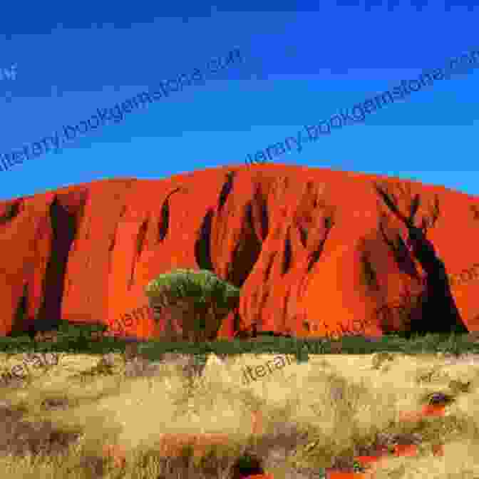 Uluru (Ayers Rock) Towering Over The Vast Desert Landscape The Red Centre Way Guide: A Complete Driving Sightseeing Guide